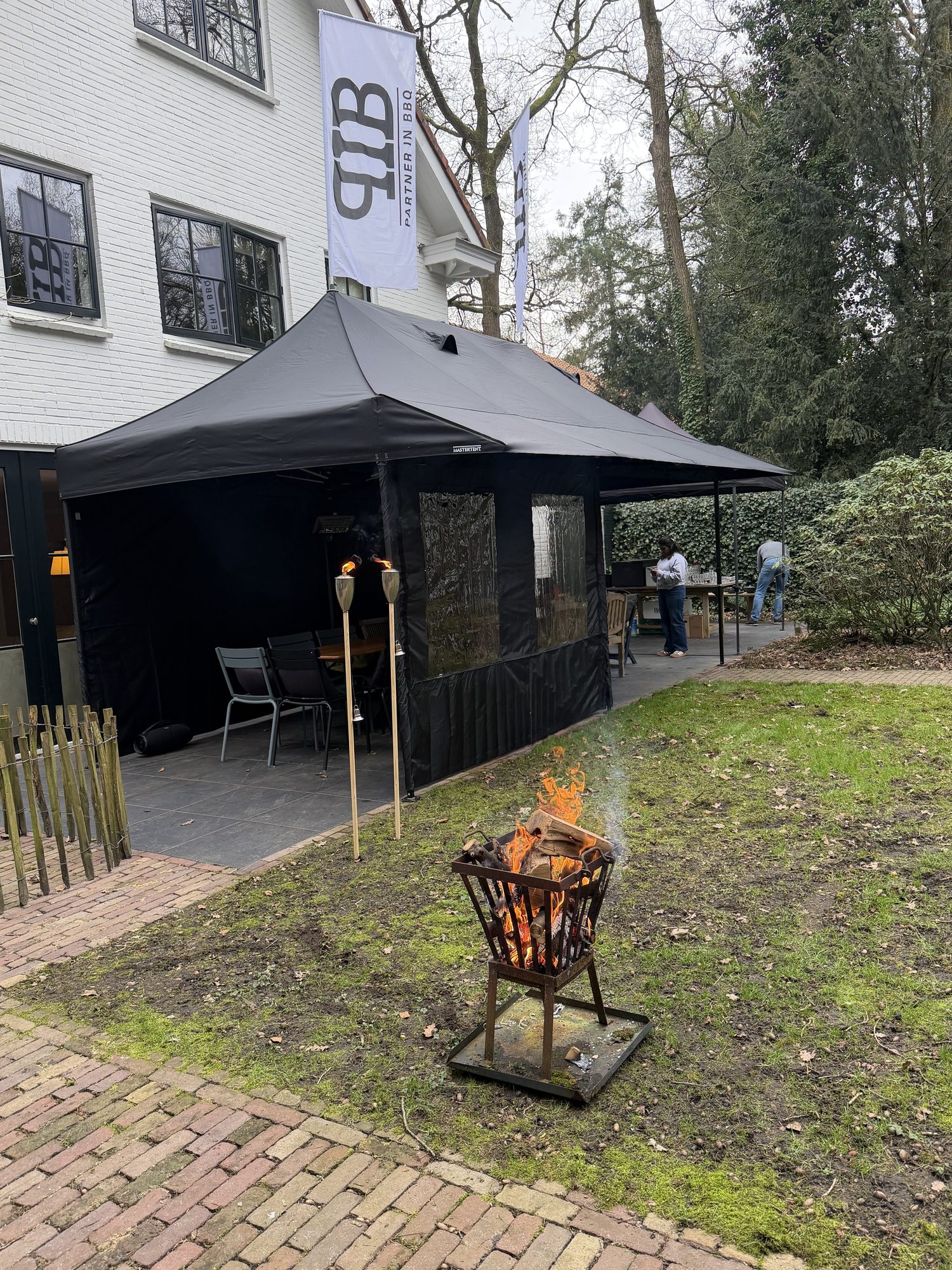 Zwarte Partner in BBQ tent met vlaggen op locatie in een tuin