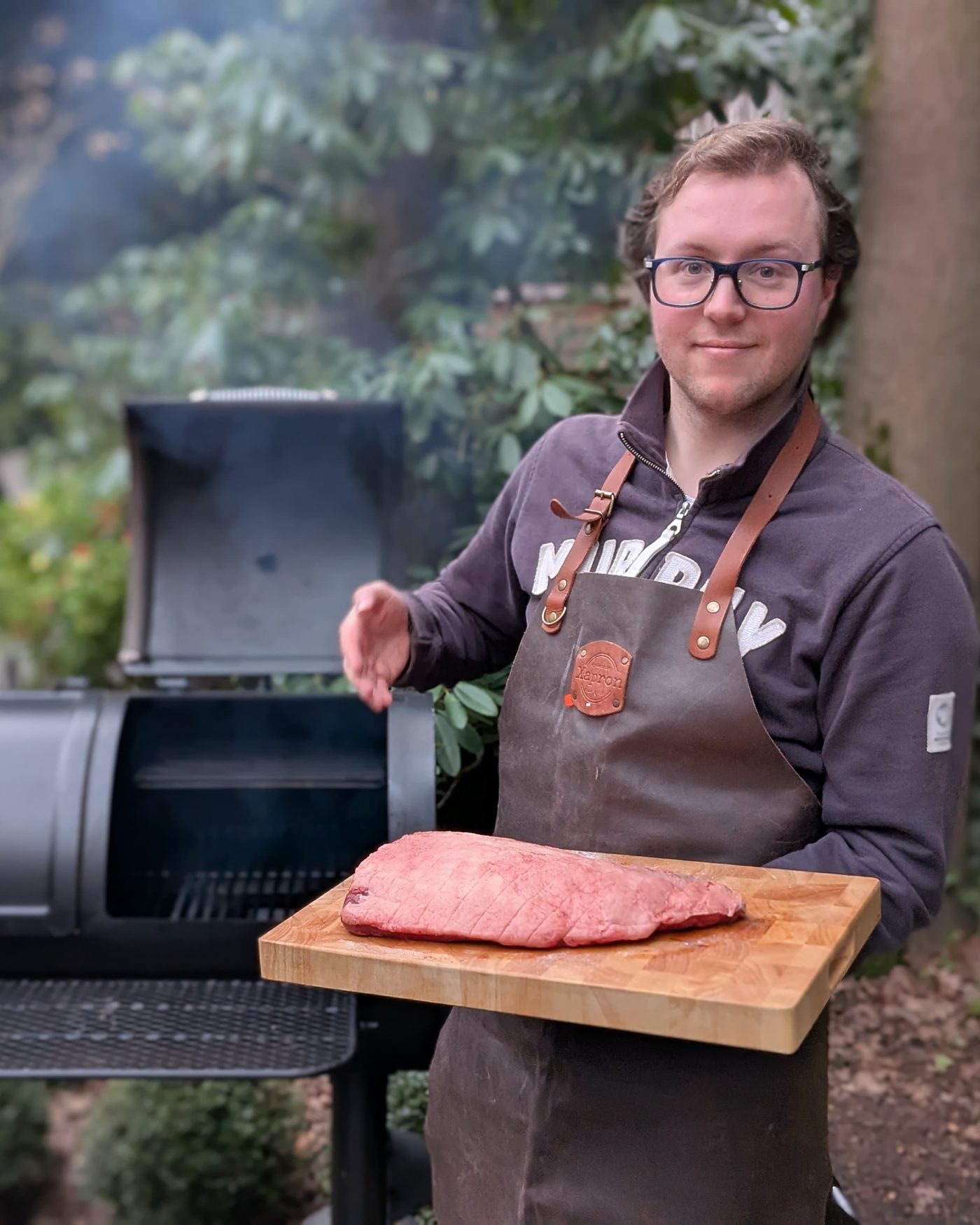 Thomas Visser van Partner in BBQ presenteert een brisket voor de houtgestookte smoker